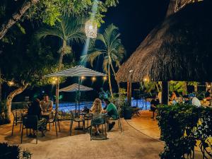 a group of people sitting at a restaurant at night at Viajero Bacalar Hostel in Bacalar