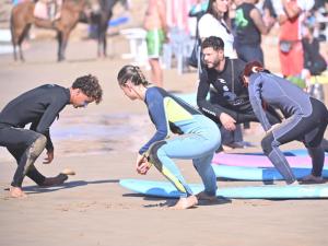 un grupo de personas en una playa con tablas de surf en mouja taghazout room, en Taghazout 21 fotos más