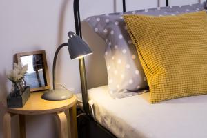 リスボンにあるOur Friends Apartmentのベッド(黄色の枕、テーブルの上のランプ付)