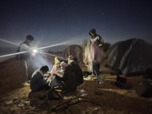 a group of people sitting in front of tents at night at Himalayan Cloud Door Camps in Dehradun