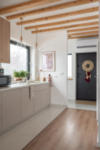 a kitchen with white cabinets and a black door at Wichrowy Domek Nowy Targ - Podhale - Tatry - Gorce - Balia in Nowy Targ