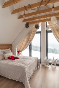 Wichrowy Domek في نوفه تارخ: غرفة نوم بها سرير ونوافذ كبيرة