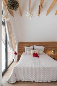 Wichrowy Domek في نوفه تارخ: غرفة نوم مع سرير أبيض مع بعرصي حمراء