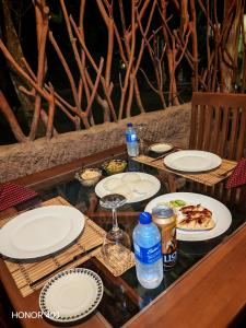 Induwara Safari Resort في اوداوالاوي: طاولة خشبية عليها أطباق طعام +69 صورة
