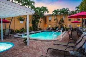 a pool with chairs and umbrellas next to a hotel at Inn at the Beach-Venice FLORIDA in Venice