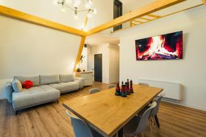 a living room with a table and a couch at Domaine A Chalet in Malu Roşu