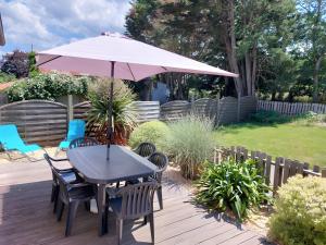 een tafel en stoelen met een parasol op een terras bij Gîte Ô Et Nature in Saint-Viaud