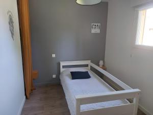 een kleine slaapkamer met een bed met een blauw kussen bij Gîte Ô Et Nature in Saint-Viaud