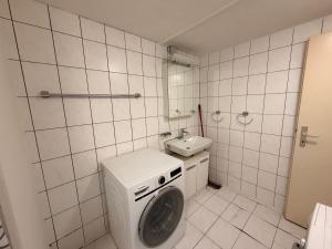 a small bathroom with a washing machine and a sink at Hostel Airport in Oberglatt +64 photos