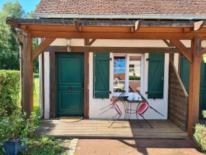 ムン・シュル・ロワールにあるChambre Japonisante, La Bonnerieの緑の扉とポーチのテーブルが付いたパーゴラ