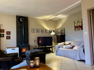 a living room with a couch and a fireplace at Maison à la campagne avec piscine in Éguzon-Chantôme