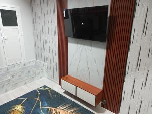 a living room with a flat screen tv on a wall at Jomi Hostel in Dushanbe
