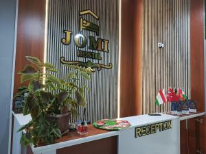 a sign on a wall with a plant on a table at Jomi Hostel in Dushanbe