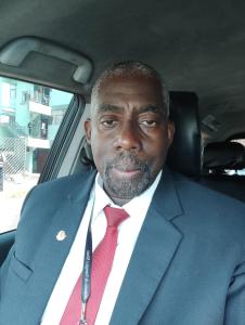 un hombre con traje y corbata sentado en un coche en Hotel britania, en Lima