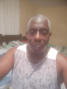 Un hombre con una camiseta blanca sonriendo a la cámara. en Hotel britania, en Lima