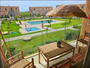 a balcony with a table and chairs and a pool at Authentic Taghazout in Taghazout