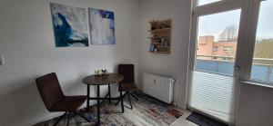 a room with a table and chairs and a window at Midtown Geeste Appartement - Free Parking & WiFi in Bremerhaven