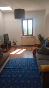 a living room with a couch and a blue rug at La Casa del Sole in Belvedere Ostrense