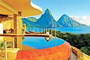 a pool with a view of the water and mountains at Jade Mountain in Soufrière