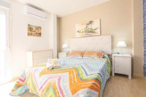 Un dormitorio con una cama grande con una manta colorida. en Sevilla Center Premium Parking Free, en Sevilla