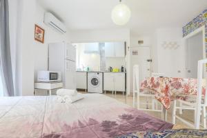Una habitación blanca con una cama y una cocina. en Sevilla Center Premium Parking Free, en Sevilla 13 fotos más