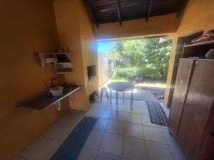 a room with a kitchen with a table and a window at Casa mami 800 mts do mar in Capão da Canoa