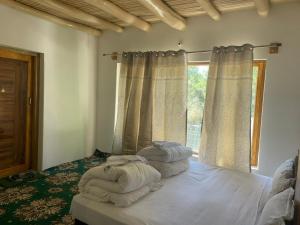 a bedroom with a bed with white sheets and a window at Baltipa Homestay in Pānāmik +3 photos