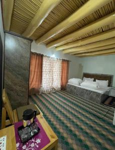 a room with a bed and a table and a table sidx sidx at Baltipa Homestay in Pānāmik