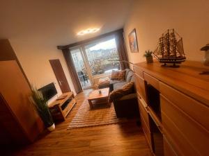 ein Wohnzimmer mit großem Fenster und einer Couch in der Unterkunft Lord Nelson Apartment 14 in Cuxhaven