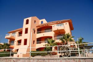 a building with a fence in front of it at Club Cantamar Beach Hotel & Marina in La Paz