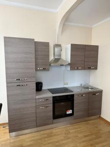a kitchen with wooden cabinets and a stove top oven at Suite Mondorf-les-bains in Mondorf-les-Bains