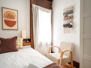 a bedroom with a bed and a chair and a window at Akisol Troia Apricot in Troia