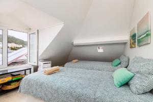 une chambre avec deux lits et une fenêtre dans l'établissement Just Sezimbra- Modern Apt 3 Min from Beach, à Sesimbra