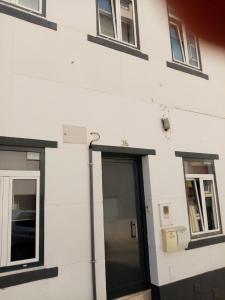 un edificio blanco con puerta y ventanas en Capital, en Almada