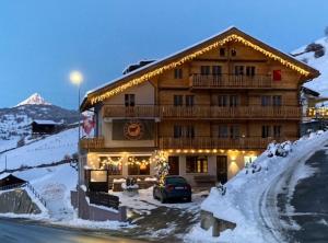a ski lodge with a car parked in the snow at Alte Bock 2.0 in Grächen