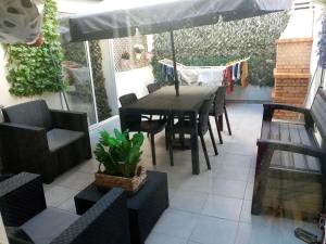 Un patio con una mesa y sillas y una sombrilla. en Capital, en Almada