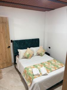 Apartamento Jardines Guaduas Cundinamarca في غوادواس: غرفة نوم بها سرير كبير عليه منشفتين