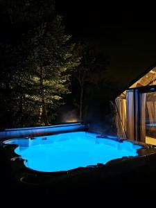a hot tub at night with a tree in the background at Domaine des pins A la belle étoile 