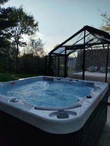 a hot tub in a backyard with a gazebo at Domaine des pins A la belle étoile 