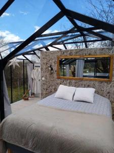 a bed in a room with a stone wall at Domaine des pins A la belle étoile 