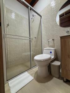 Apartamento Jardines Guaduas Cundinamarca في غوادواس: حمام مزود بمرحاض ودش زجاجي +8 صور