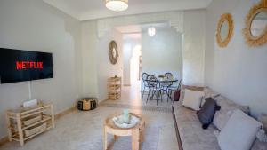 a living room with a couch and a table at Appartement cosy, calme, détente, piscines, jardins in Marrakech
