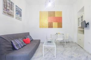 una sala de estar con un sofá y una mesa en Galindo Center Premium Suites, en Sevilla