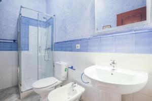 Un baño con inodoro, lavabo y ducha. en Galindo Center Premium Suites, en Sevilla 17 fotos más