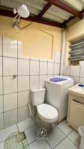 baño con aseo y ventilador de techo en Sobrado aconchegante próximo do mar, en Passo de Torres