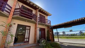 una casa con una puerta delante de ella en Sobrado aconchegante próximo do mar, en Passo de Torres