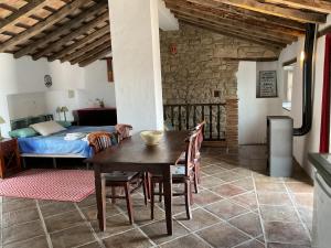 希梅纳德拉夫龙特拉Casa Rural Los Sentidos Jimena的一间带桌子和床的用餐室