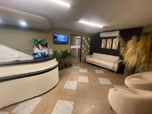 a living room with a tv and a couch in it at Pousada Maré Alta Pajuçara in Maceió