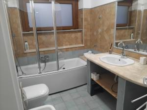 a bathroom with a tub and a toilet and a sink at Dimora Alta in Olbia