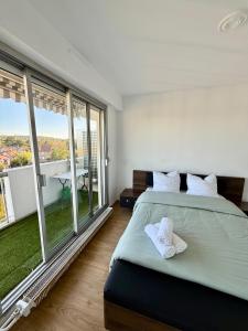 une chambre avec un grand lit et de grandes fenêtres dans l'établissement Appartement vue sur Tour Eiffel, à Garches